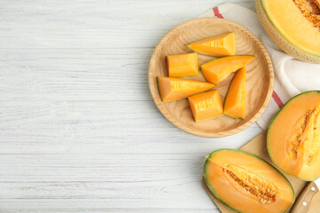 Tasty fresh cut melons on white wooden table, flat lay. Space for text
