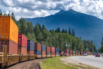 Cargo train on track through a mountain town