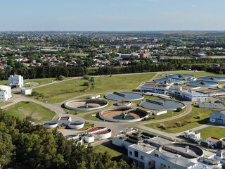 Vista aérea de una planta dedicada al tratamiento de efluentes de agua y la ciudad al fondo