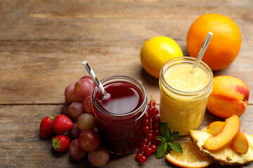 Delicious colorful juices in glasses and fresh ingredients on wooden table