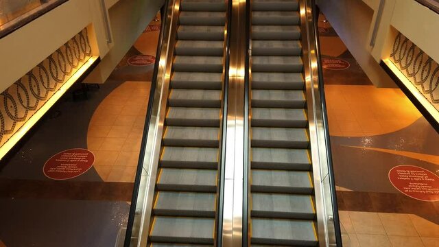 Top view of an escalator in the middle of empty mall during lockdown.