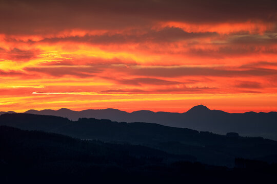 Coucher de soleil sur la Chaine des puys en Auvergne. Paysage touristique auvergnat. Du Puy de d&ocirc;me jusqu'au Sancy. Montagnes et Panorama. Ciel rouge et nuageux lors du soleil couchant.