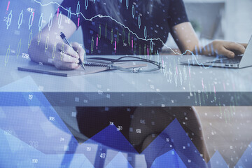 Double exposure of businesswoman hands typing on computer and forex chart hologram drawing. Financial analysis concept.