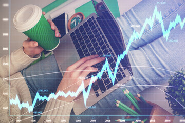 Double exposure of woman hands typing on computer and forex chart hologram drawing. Stock market...