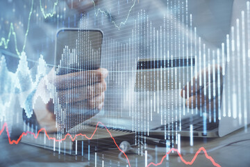 Double exposure of man hands holding a credit card and Forex graph drawing. Stock trading and digital fintech in Internet E-commerce concept.