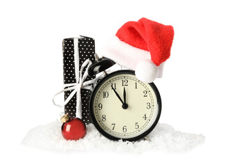 Alarm clock with Santa hat, gift and Christmas ball in pile of snow on white background. New Year...
