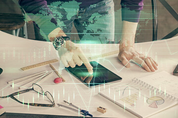 Double exposure of man's hands holding and using a digital device and forex graph drawing. Financial market concept.