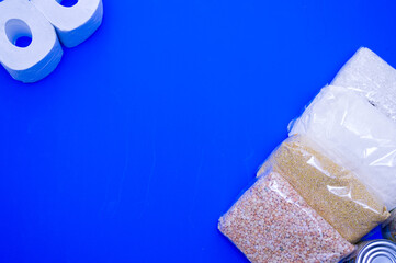 Cardboard box with Food supplies crisis food stock for quarantine the blue background. Rice, canned food, toilet paper. Food delivery. coronavirus quarantine concept