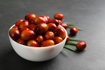Palm oil fruits in bowl on black table, closeup