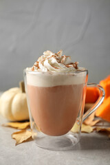 Delicious pumpkin latte on grey table, closeup