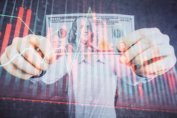 Multi exposure of financial graph drawing hologram and USA dollars bills and man hands. Analysis concept.