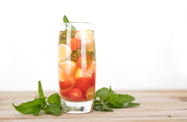 A cup of lemon mixed fruit tea and fresh mint leaves