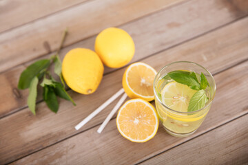 Obraz na płótnie Canvas A cup of lemon mint tea and freshly cut lemon fruit
