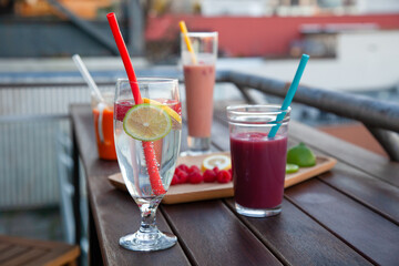 An outdoor patio bar top with a fruit platter, and glass drinks with food-grade, silicone straws which are reusable and a plastic-alternative that is more sustainable