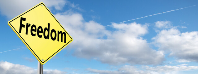 Blue sky and yellow road sign with text freedom