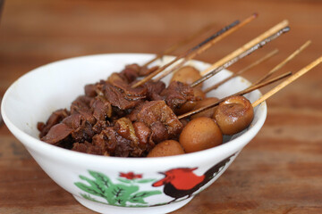 Meat satay and quail egg satay in a bowl
