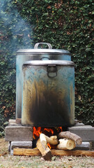 Fototapeta premium Traditional cooking. Cook water in a large pot using firewood