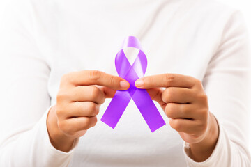 National Epilepsy or Alzheimer disease Day. Young woman holding purple ribbon on hand symbol of...