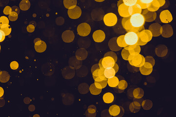 Gold bokeh from light in water with black background