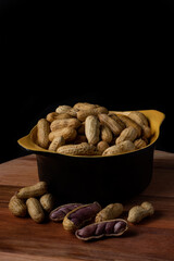 Boiled peanuts (amendoin cozido, sergipe, nordeste, Brazil) in a black and yellow bowl and boiled peanuts spread and open outside the bowl