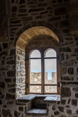 Fototapeta na wymiar View of the window in the thick stone wall from inside the tower of Genoese fortress of 14th century in the Sudak bay on the Peninsula of Crimea