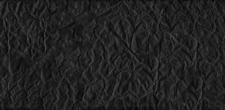 Crumpled black paper of texture background. © meepoohyaphoto