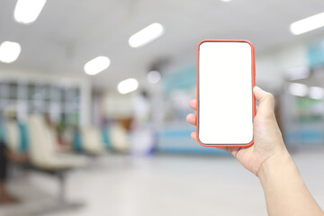 Hand of a man holding smartphone device in the hospital blur background.