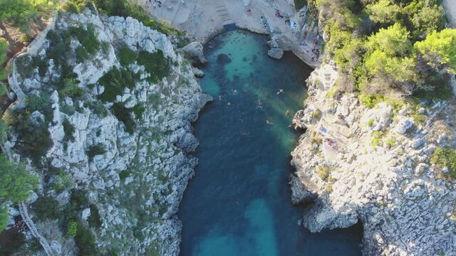 Europa Italien Sommer Drohne Flug &uuml;ber Bucht Strand Felsen Wand am Meer w&auml;hrend Corona Covid Pandemie Urlaub Ferien t&uuml;rkis Ozean sch&auml;umende Wellen Reise Drohnenflug Steigflug 4k