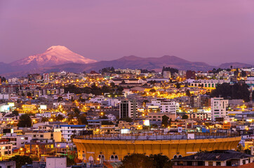 The bullfighting arena of Quito city at night in a modern district with the Cayambe volcano,...