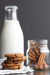 Ginger snap cookies with milk in milk bottle with cinnamon sticks