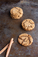 Ginger snap cookies with cinnamon sticks on cookie sheet