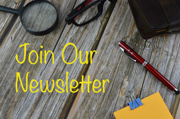Top angle view of notebook, glasses,pen, memo note and magnifying glass  with word Join Our...