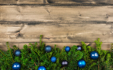 Christmas background with green branches and christmas balls on the rustic wooden background....