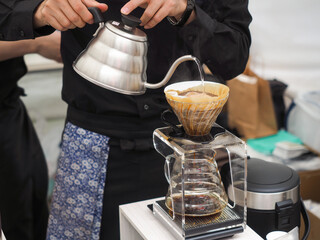 Cafe professional barista brews coffee by an alternative method in pour over. Coffee maker and drip...