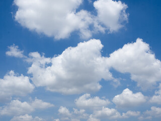 Naklejka na ściany i meble Clear blue sky background with white fluffy clouds.