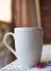 cup of tea in a table with a window in the background and a sunset