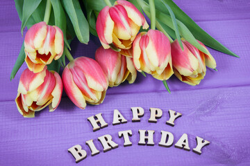 Inscription happy birthday and fresh tulips on boards. Surprise for birthday