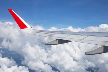 View of sky, cloud and wing of airplane from window