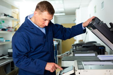 Obraz premium Service engineer using a copy machine. High quality photo