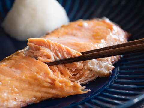 グリルで焼いた鮭の切り身。箸でほぐして食べるところ。