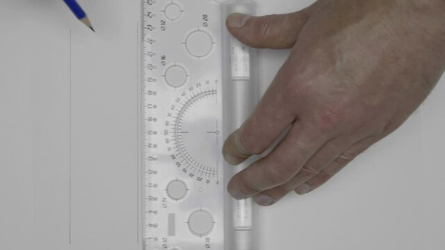 An engineer (apprentice, apprentice, designer) easily draw parallel lines on a white sheet with a transparent roller ruler