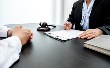 Fototapeta premium A woman lawyer or a judge counseling clients about judicial justice and prosecution with scales, judges gavel, legal documents legal services concept