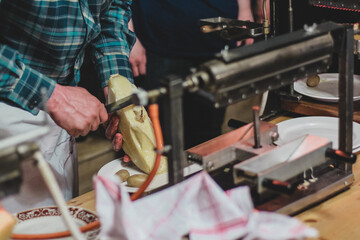 Fototapeta premium Detail of a raclette maker. Gourmet food being prepared under a gas heater above cheese.
