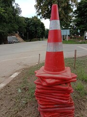 A red traffic cone is located along the roadside.