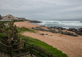 Wooden Stairway Leading Through Vegetation onto Rocky Beach