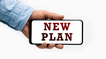 Closeup of a male hand holding Smartphone with text NEW PLAN on display