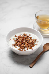 yogurt with sunflower seeds in a ceramic bowl