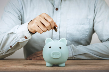 Businessman save money on piggy bank , Hand put money coin into piggy bank for save