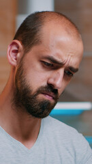 Fototapeta premium Tired man squinting eyes looking at laptop screen trying to focus concentrate. Busy focused employee using modern technology network wireless doing overtime for job reading writing, searching