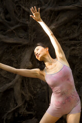 Active woman dancing with overturned tree roots in Manchester, Connecticut.